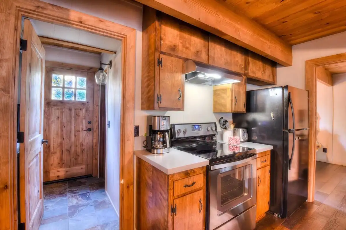Kitchen with wood cabinets and a door to the entry, Enchanting Chamberlands Cabin