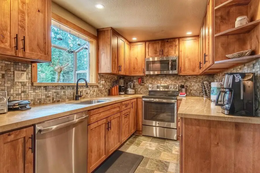 Kitchen with wood cabinets, mosaic backsplash and window over the sink, Restful North Ridge