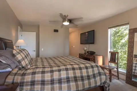 Bedroom with plaid bedding, ceiling fan and wall TV, Skylake Serenity Retreat
