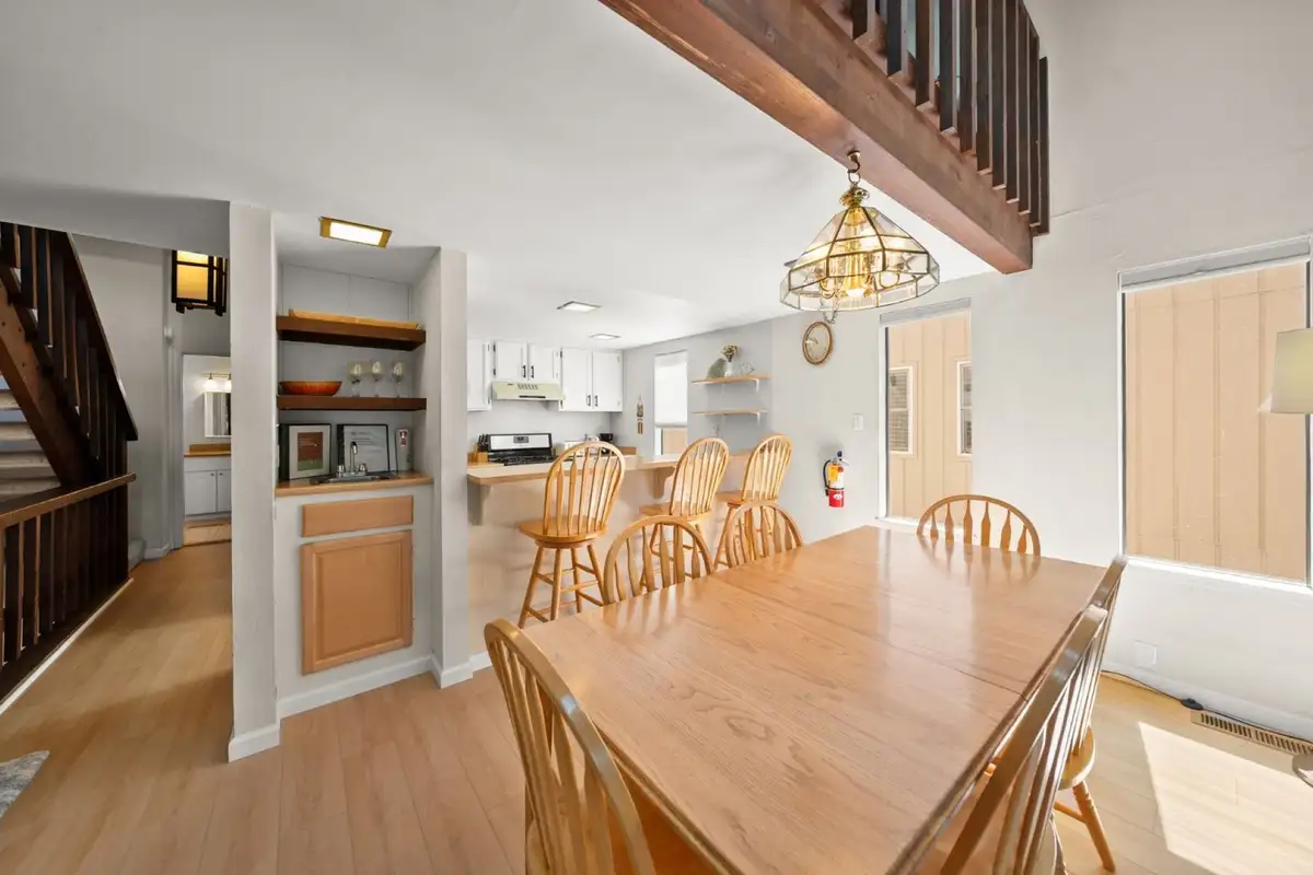Long dining table with wooden chairs and staircase, Skiway Suite