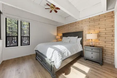 Loft bedroom with queen bed, vaulted wood-beam ceiling, and ceiling fan, Treetop on Country Club