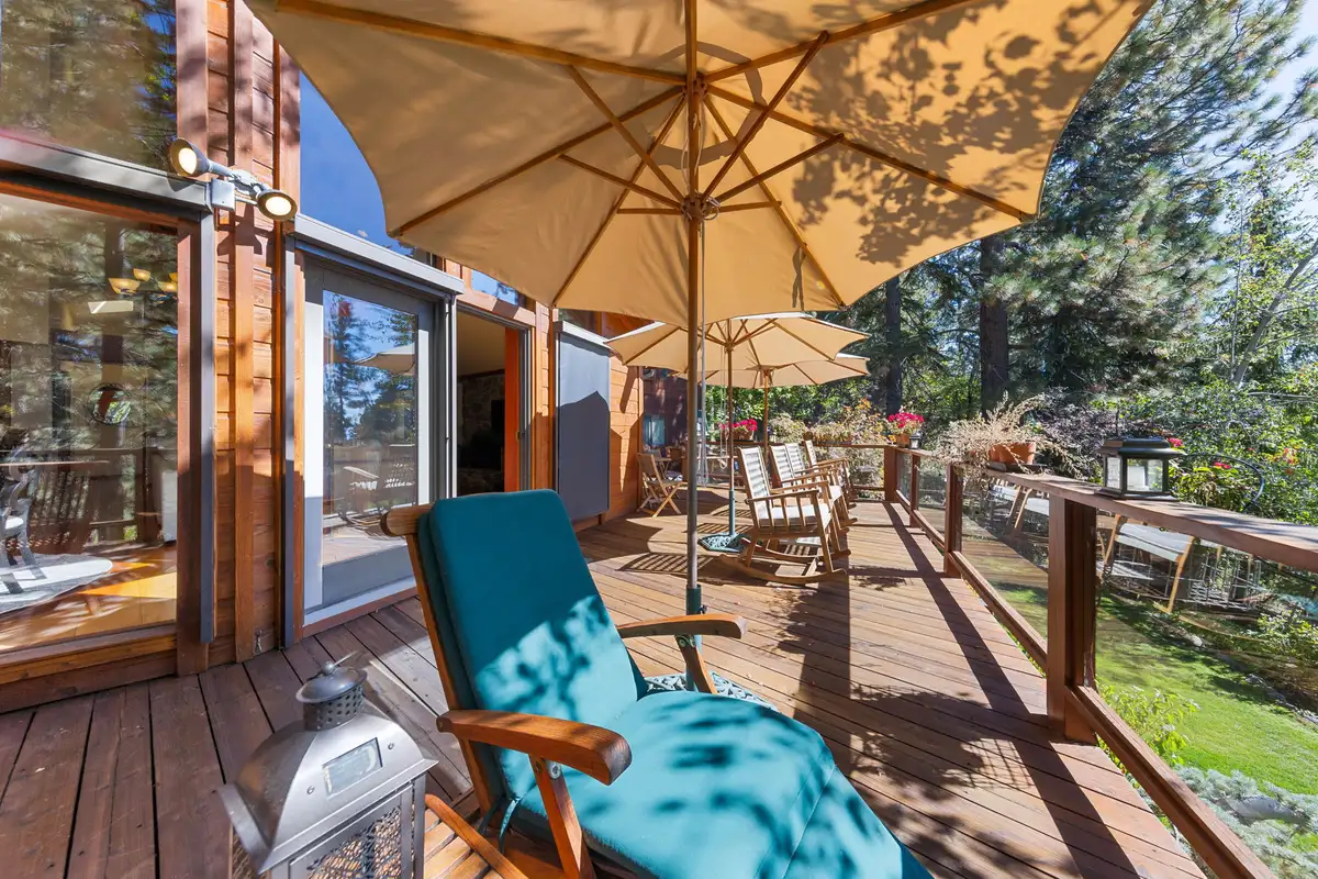 Deck with lounge chair and umbrellas beside a lawn, Incline Lakeside Haven