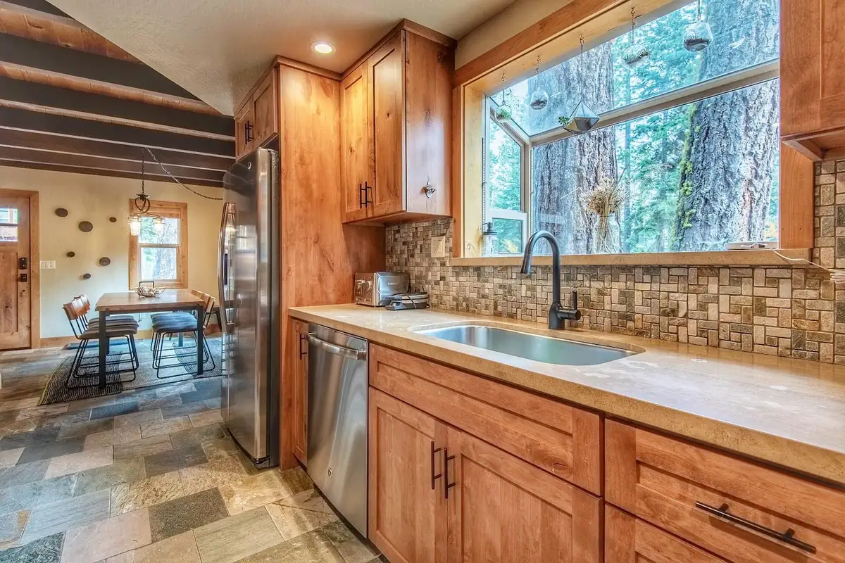Kitchen with wood cabinets and large window facing tall pines, Restful North Ridge