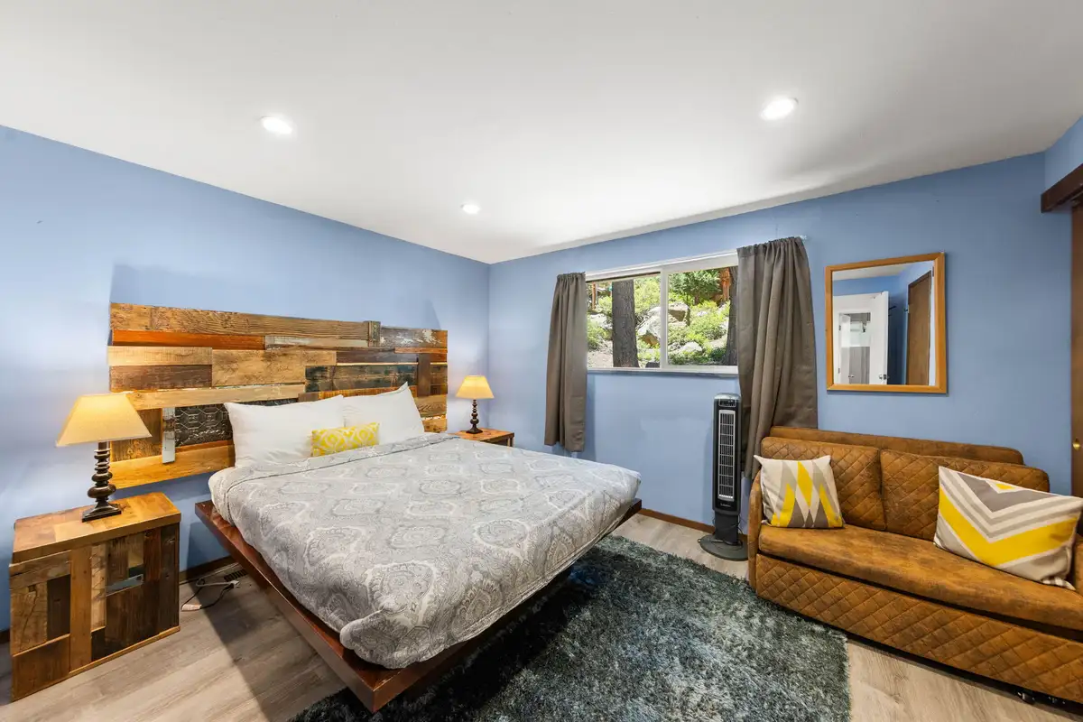 Blue-walled bedroom with a reclaimed wood headboard and sofa, Tahoe Lake & Mountain Retreat