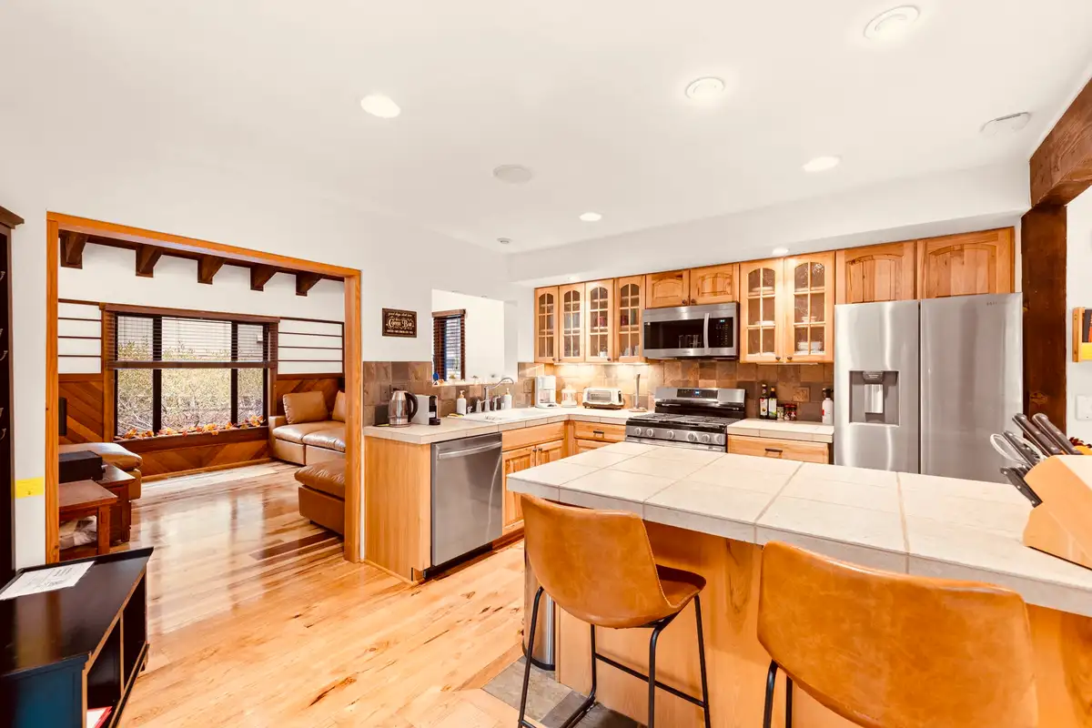 Kitchen with island stools and stainless appliances, Sunlit Incline Retreat