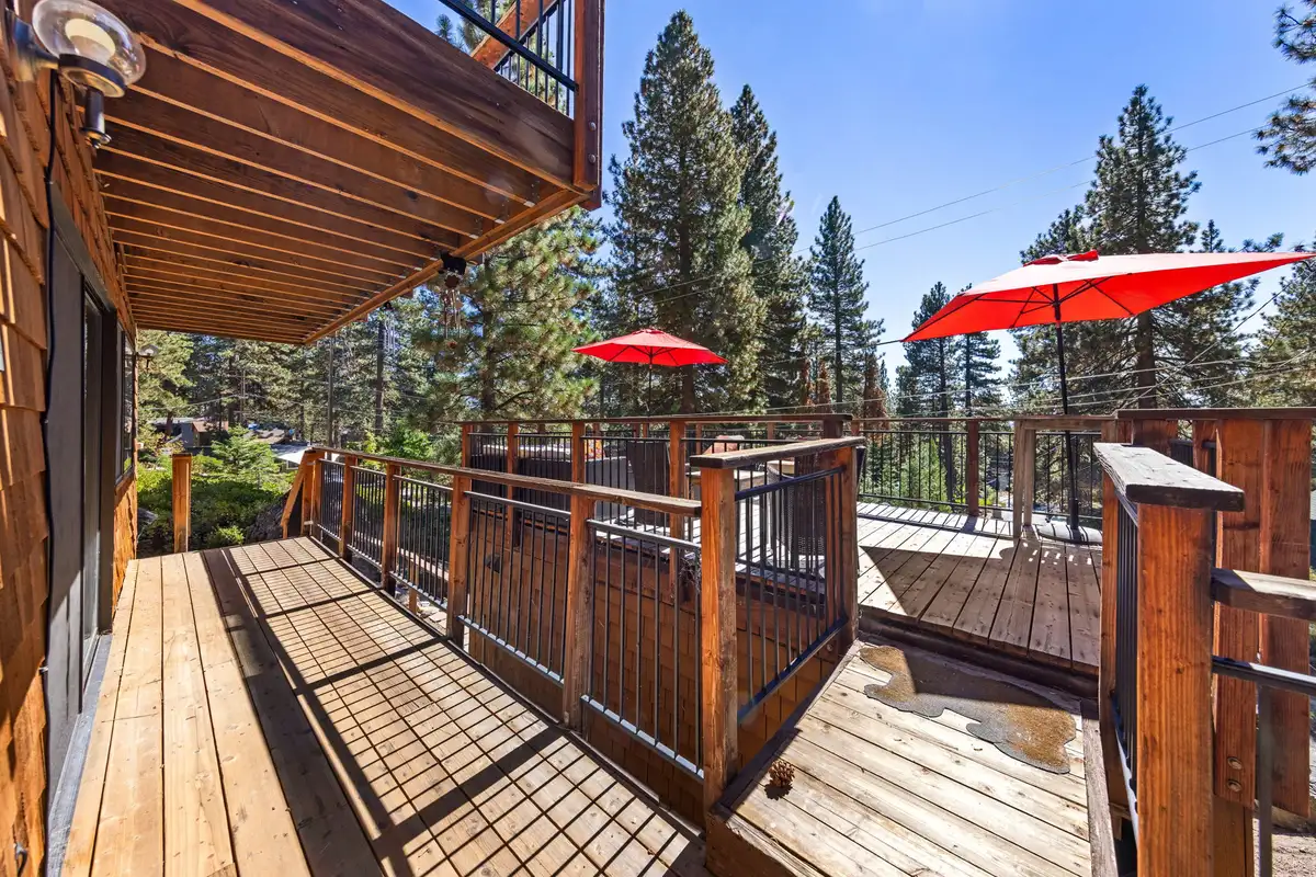 Wood deck with red umbrellas among pines, Rustic Ridge Retreat