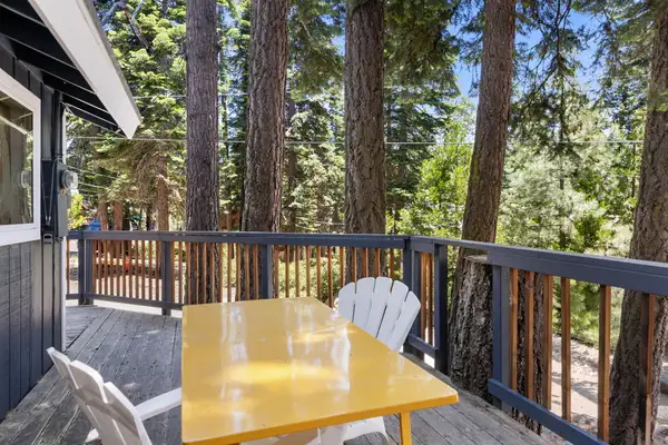 Deck with a yellow table and chairs among tall pines, Tahoe Lake & Mountain Retreat