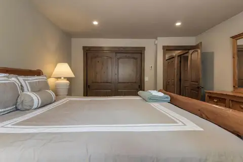 Bedroom with a bed and wood double doors, Tranquil Tahoe Haven