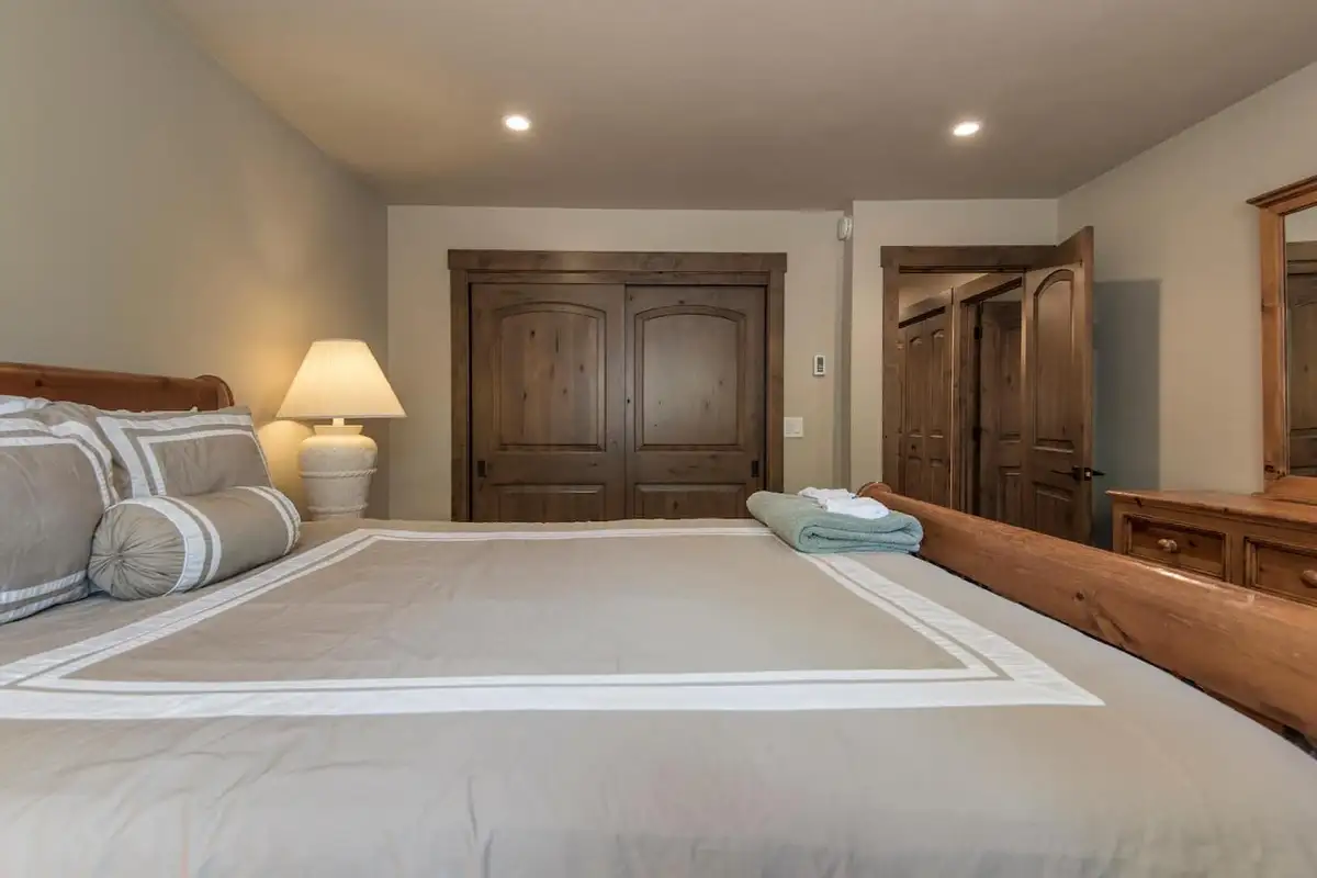 Bedroom with a bed and wood double doors, Tranquil Tahoe Haven