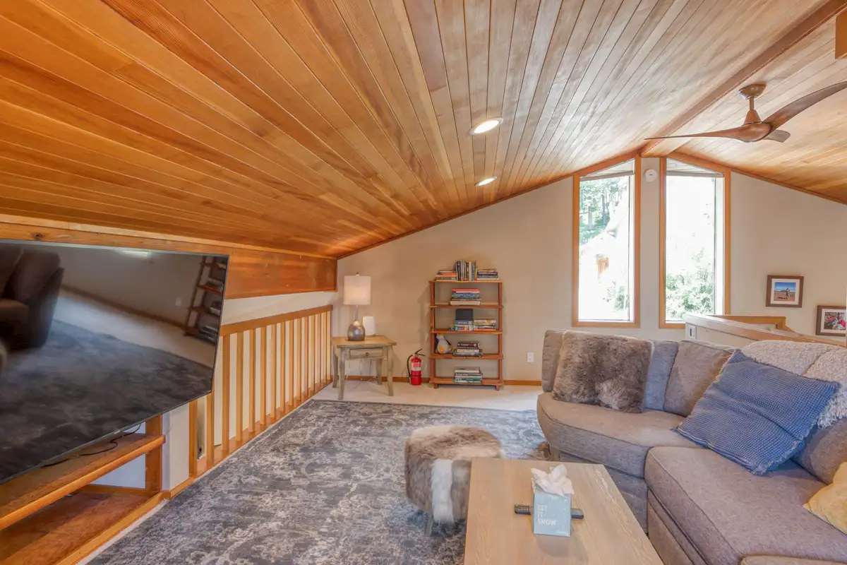 Loft with sectional sofa, wood ceiling and stair railing, Lunar Lakeview Haven