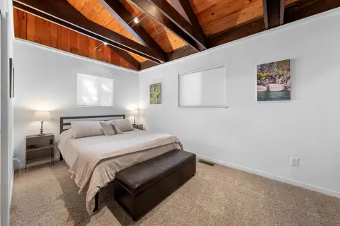Bedroom with a bed and exposed beam ceiling, Updated West Shore Cabin 1 mile to Chambers Beach