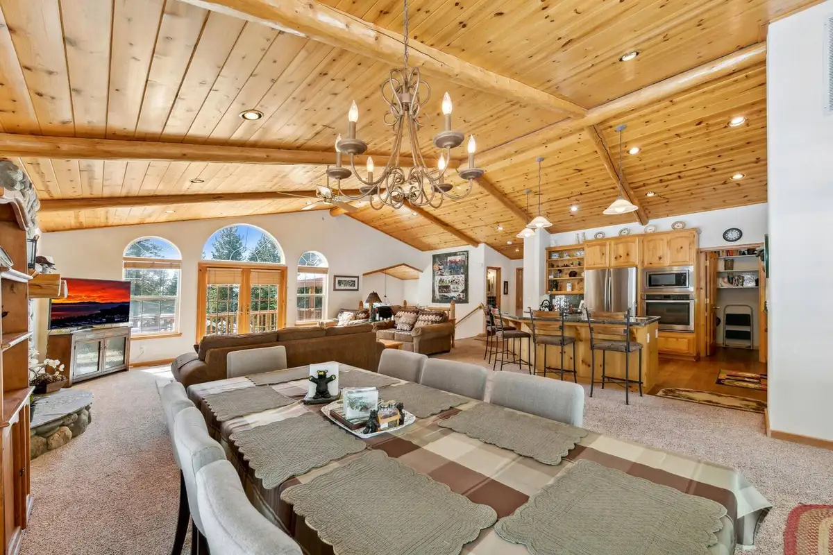 Long dining table with chandelier in an open great room, Hastings Hideaway Cabin