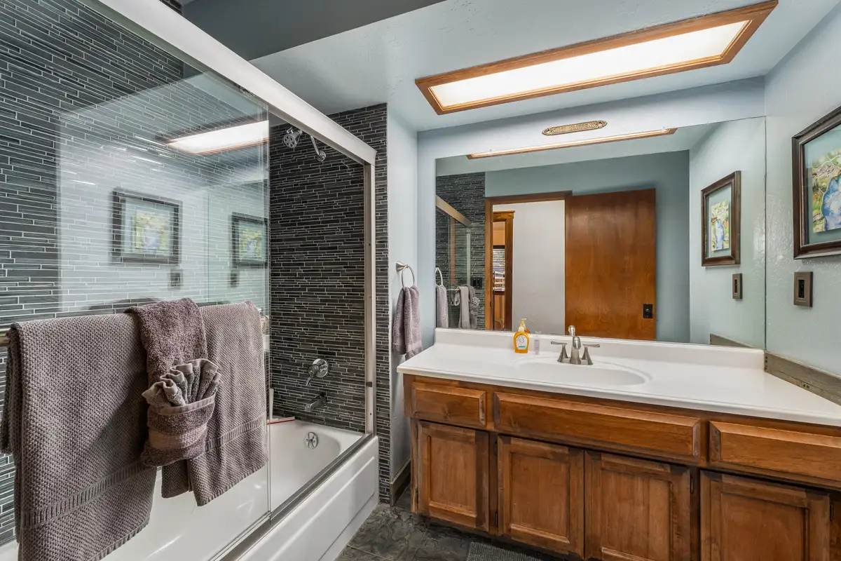 Bathroom with a tub-shower and wood vanity, Grand Regency Retreat