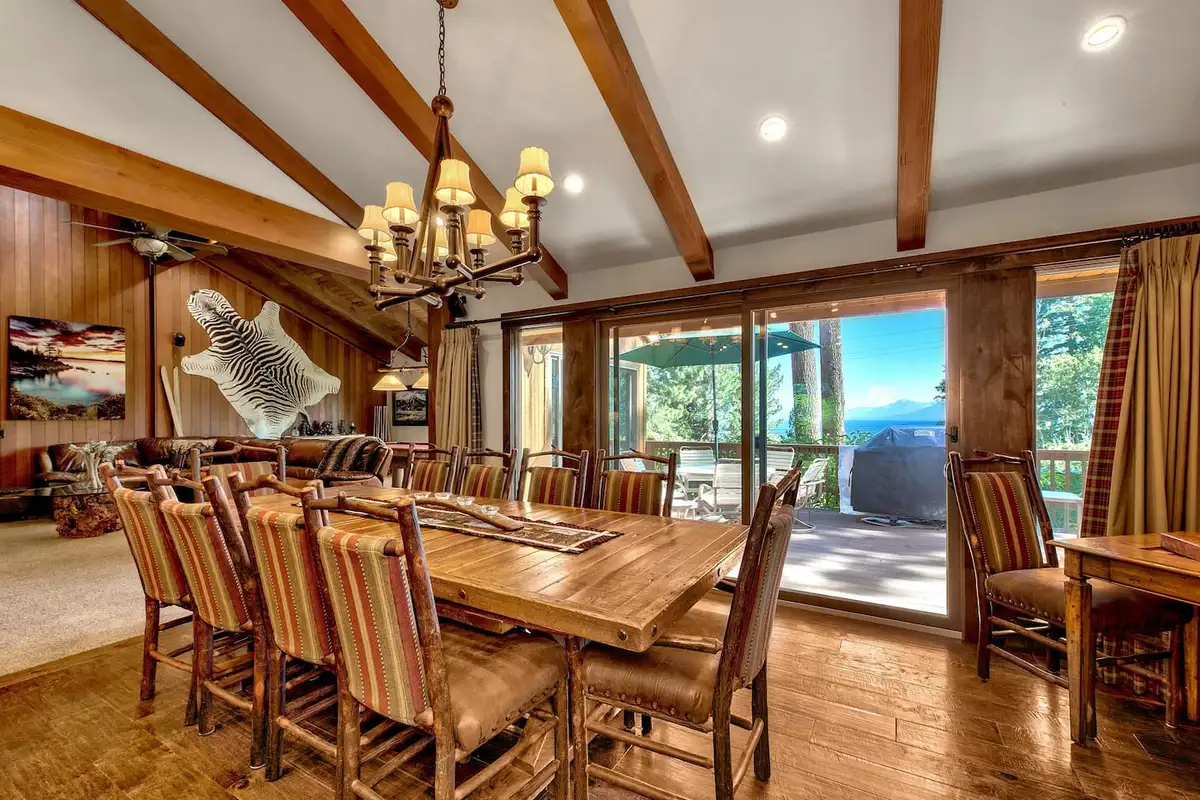 Dining table under a chandelier with sliding doors to a deck, Mammoth Haven Retreat