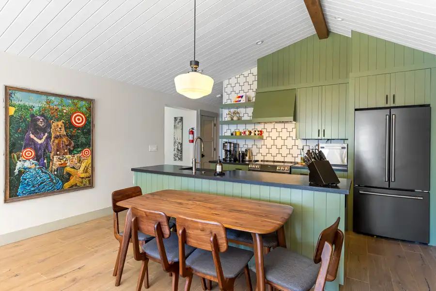 Kitchen with green cabinets and wood dining table, Lakeside Luxe Retreat