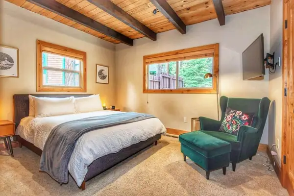 Bedroom with a bed, green armchair and ottoman, Restful North Ridge