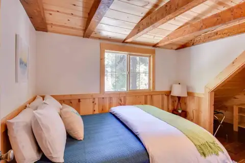 Bedroom with a bed under a beamed pine ceiling, Tranquil Trails Cabin