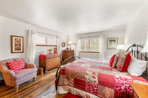 Bedroom with a quilted bed and armchair, Evergreen Hideout
