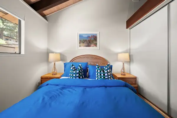 Bedroom with a blue-covered bed and mirrored closet, Skiway Suite