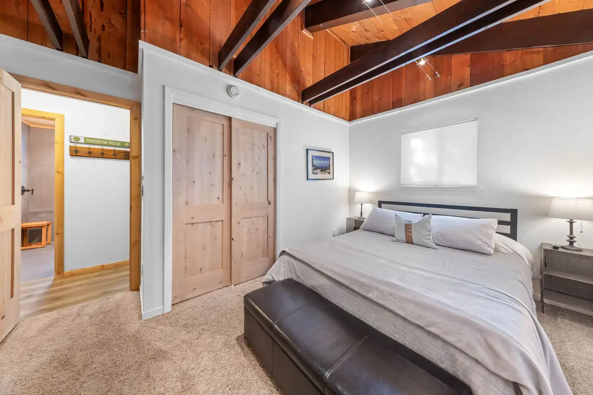 Bedroom with a bed, leather bench and closet doors, Updated West Shore Cabin 1 mile to Chambers Beach