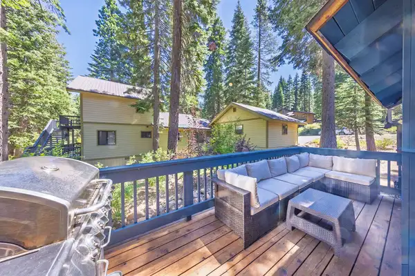Deck with outdoor sectional and grill among pines, Grand Regency Retreat