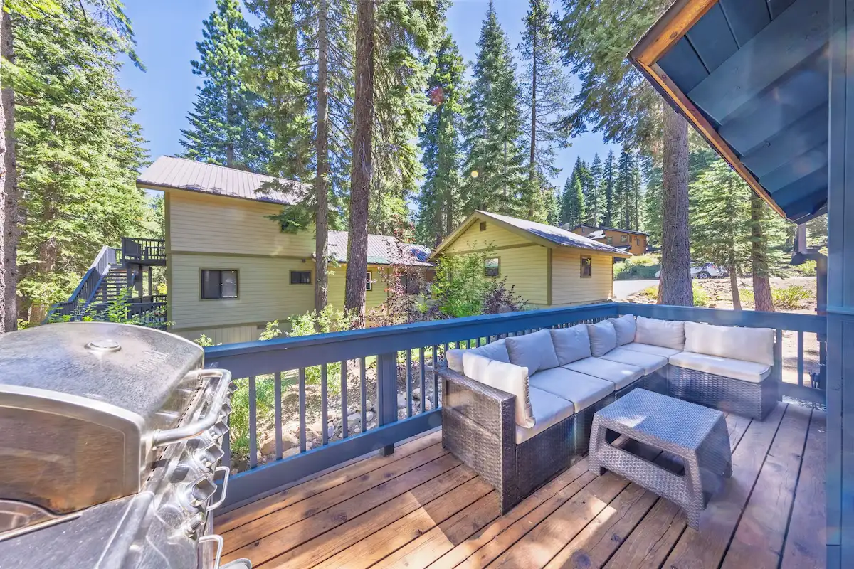 Deck with outdoor sectional and grill among pines, Grand Regency Retreat