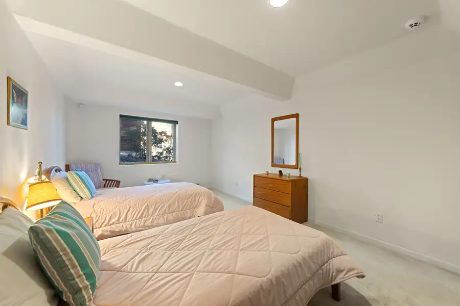 Bedroom with two beds and a wood dresser, 90s Tahoe Time Capsule