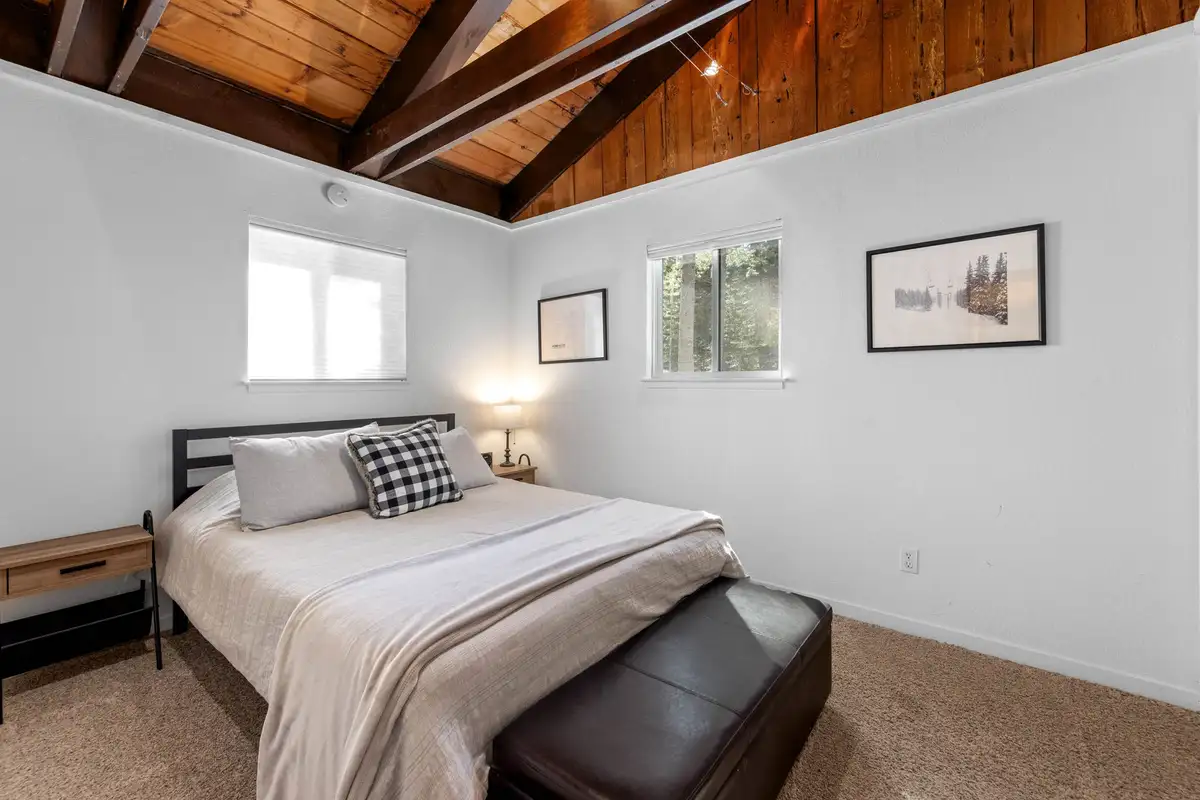 Bedroom with a bed and exposed wood beam ceiling, Updated West Shore Cabin 1 mile to Chambers Beach