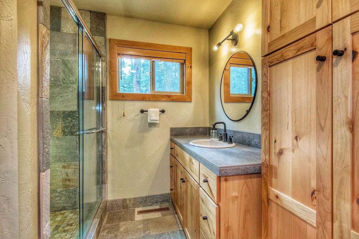 Bathroom with a glass shower and round mirror, Restful North Ridge