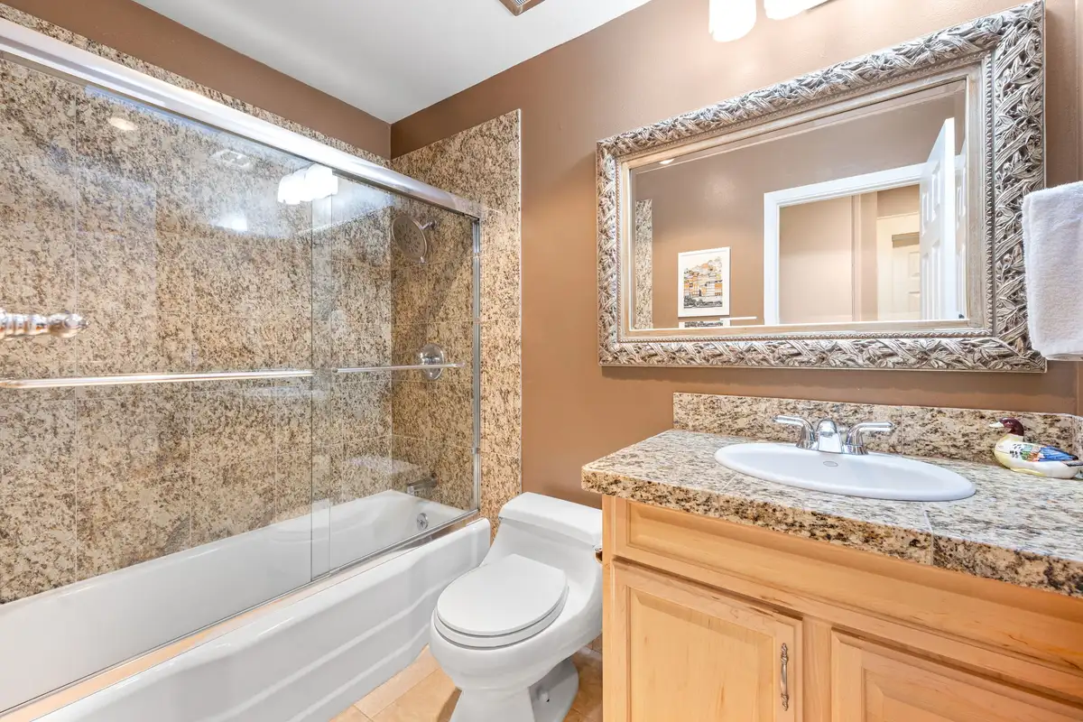 Bathroom with a granite vanity and tub with glass doors, Tranquil Stay