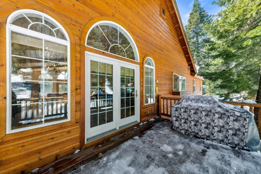 Deck with a covered grill beside arched French doors, Hastings Hideaway Cabin