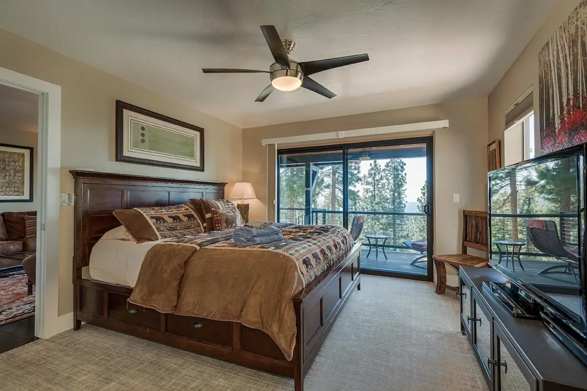 Bedroom with a wood bed frame, TV and sliding doors, Skylake Serenity Retreat