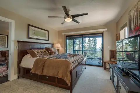 Bedroom with a wood bed frame, TV and sliding doors, Skylake Serenity Retreat
