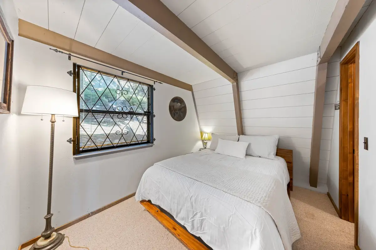 A-frame bedroom with a bed and diamond-pane window, Livin' on the Edge