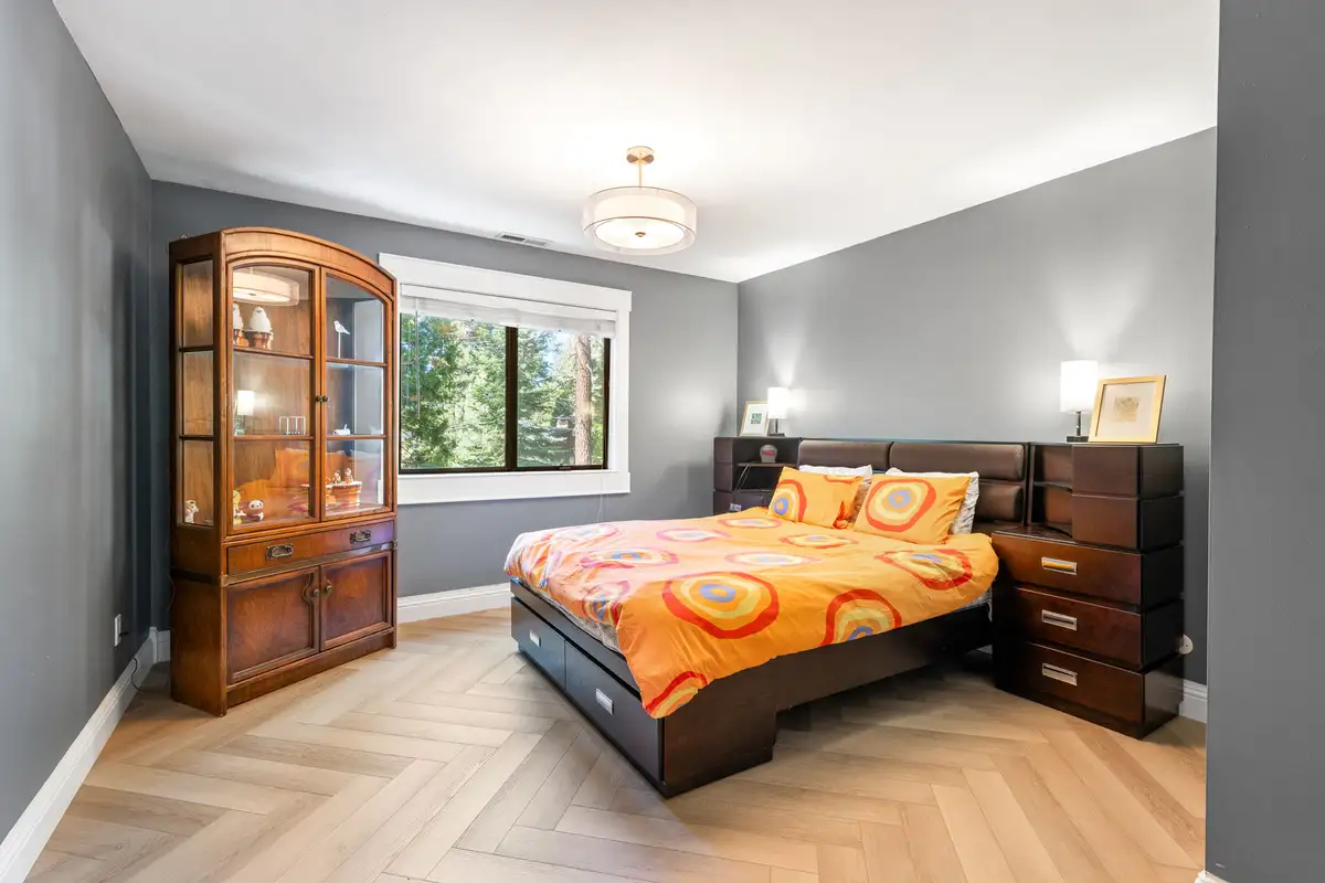 Bedroom with a bed, orange bedding and wood hutch, Tranquil Stay