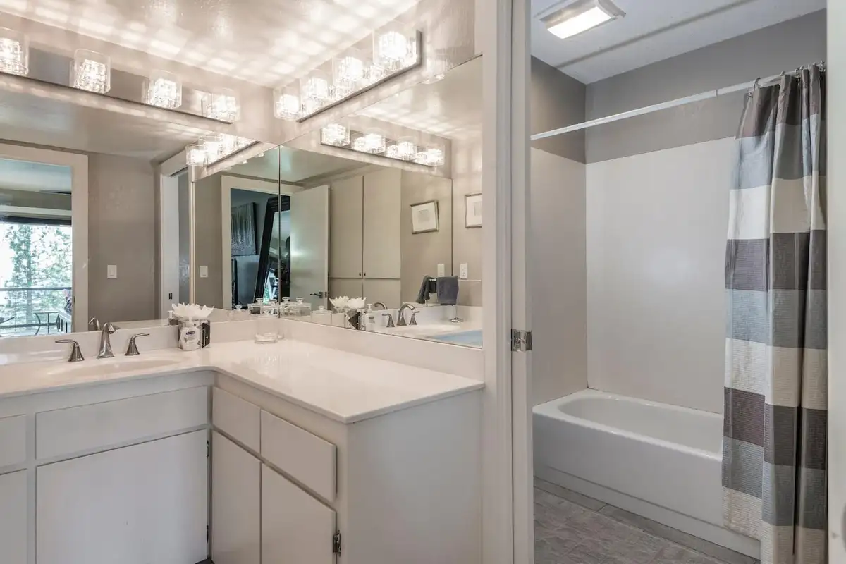 Bathroom with a white double vanity and tub with curtain, Skylake Serenity Retreat