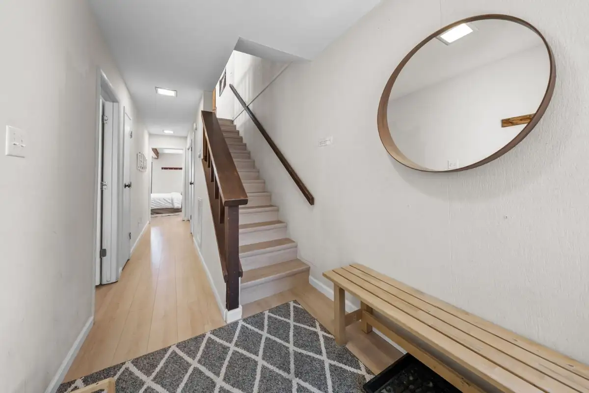 Entry hallway with stairs, bench and round mirror, Skiway Suite