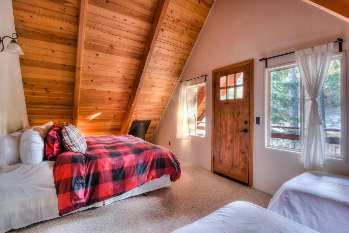 A-frame bedroom with beds and buffalo plaid bedding, Enchanting Chamberlands Cabin