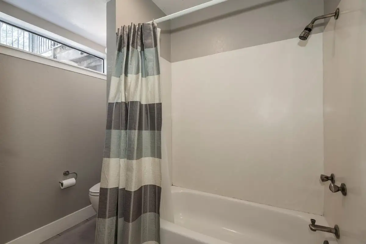 Bathroom with a tub and striped shower curtain, Skylake Serenity Retreat