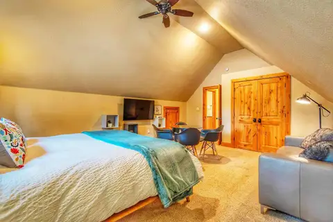 Loft bedroom with a bed, ceiling fan and sloped ceiling, Restful North Ridge