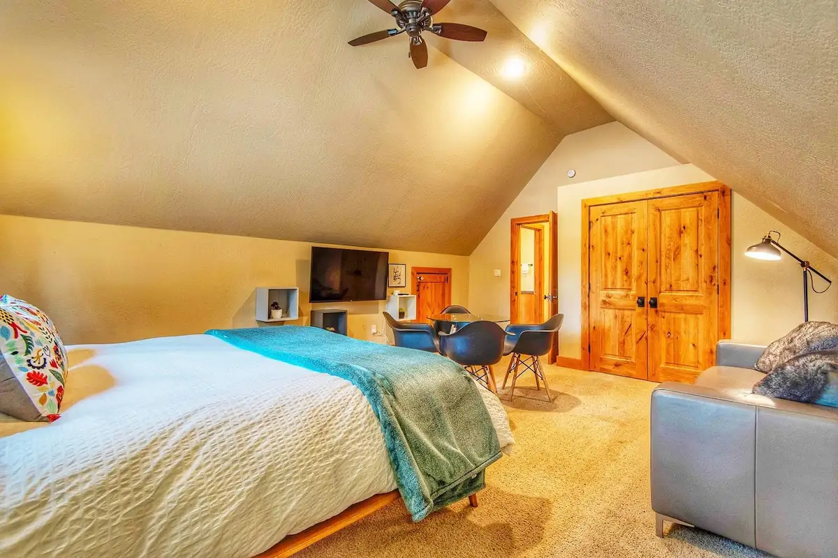 Loft bedroom with a bed, ceiling fan and sloped ceiling, Restful North Ridge