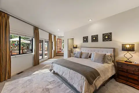 Bedroom with a bed and wall of windows to the deck, Incline Lakeside Haven