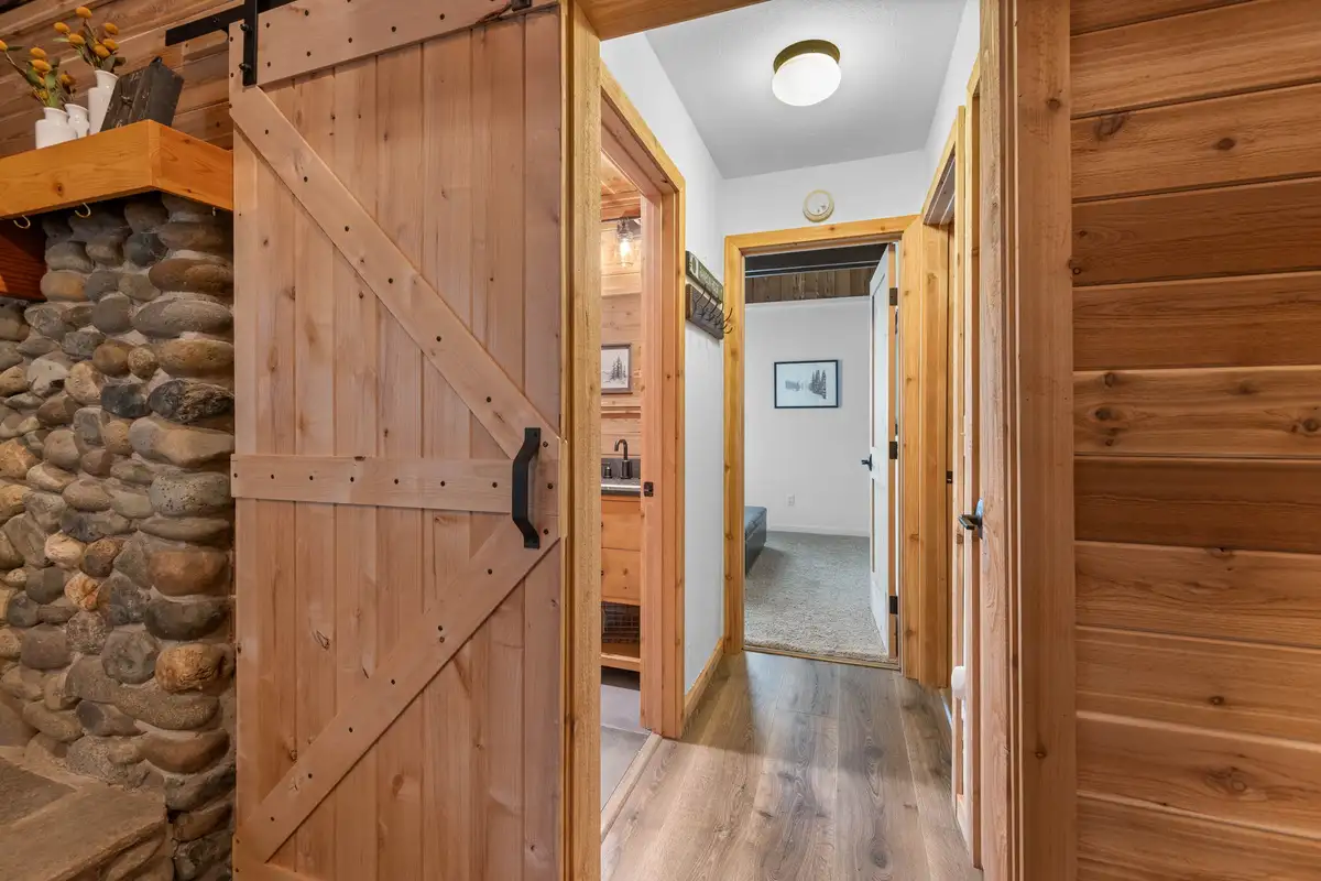 Hallway with sliding barn door and river rock wall, Updated West Shore Cabin 1 mile to Chambers Beach