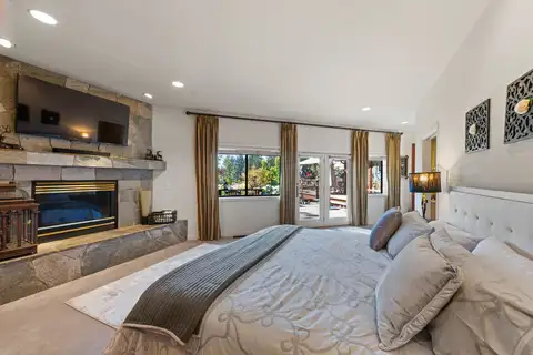 Bedroom with a bed and stone fireplace, Incline Lakeside Haven