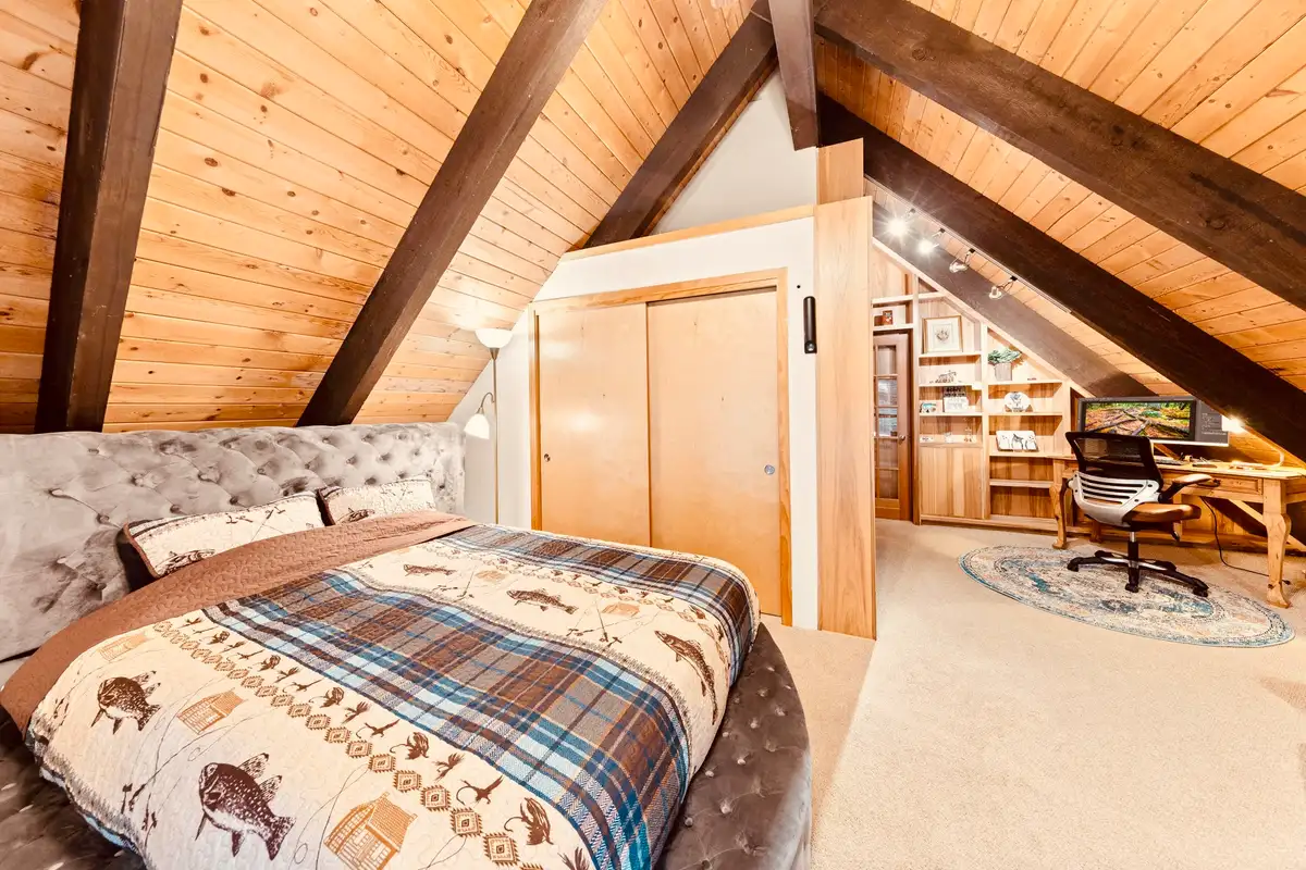 Loft bedroom with sloped wood ceiling and a desk, Sunlit Incline Retreat