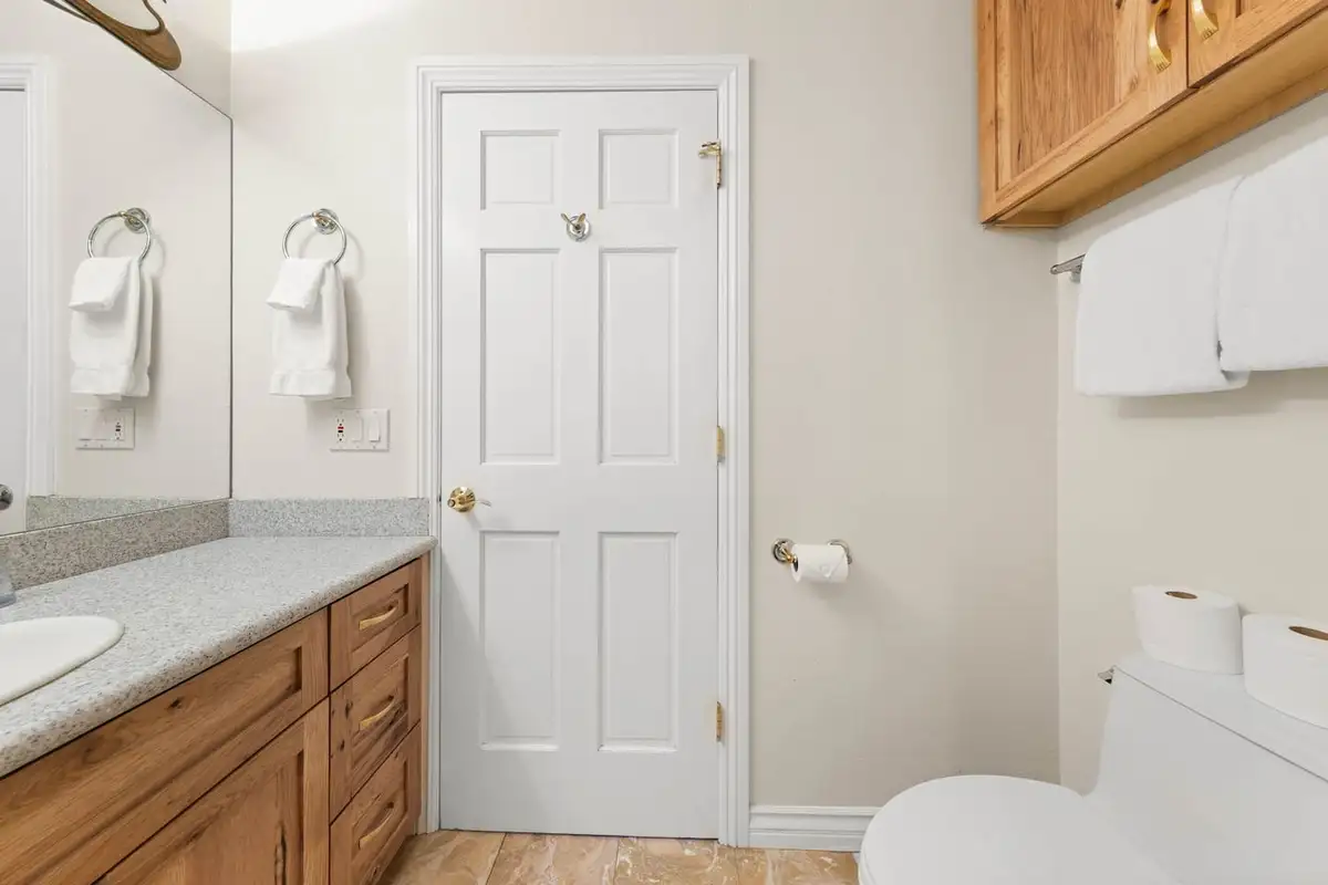 Bathroom with a wood vanity, towel rings and toilet, Tranquil Alpine Bliss