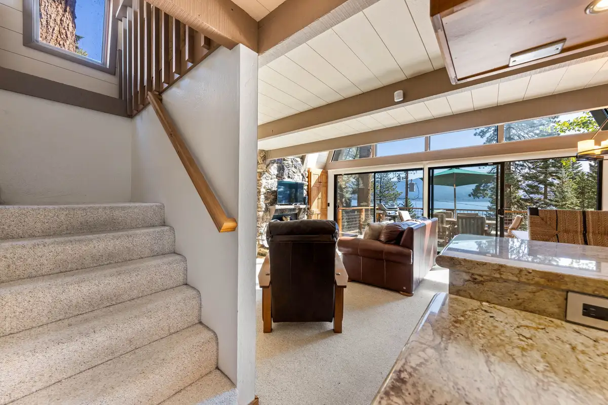 Carpeted stairs leading down to a lake view living room, Livin' on the Edge