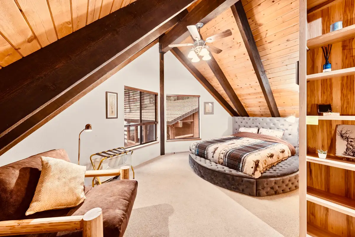 Bedroom with a round bed under a sloped wood ceiling, Sunlit Incline Retreat