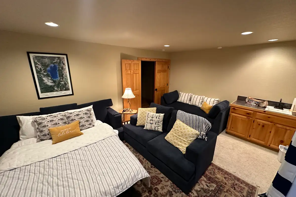 Room with a bed and a dark loveseat, Lakeview Grandeur