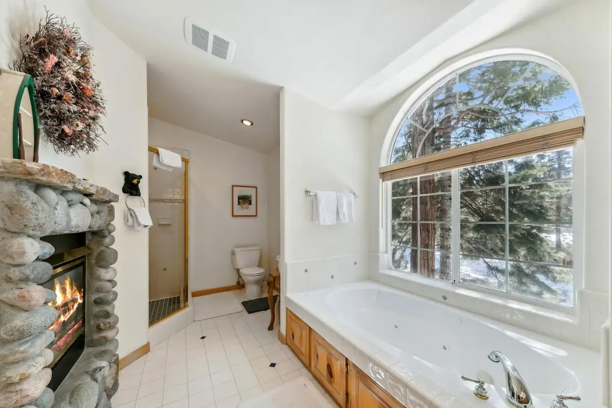 Bathroom with stone fireplace beside a jetted tub, Hastings Hideaway Cabin